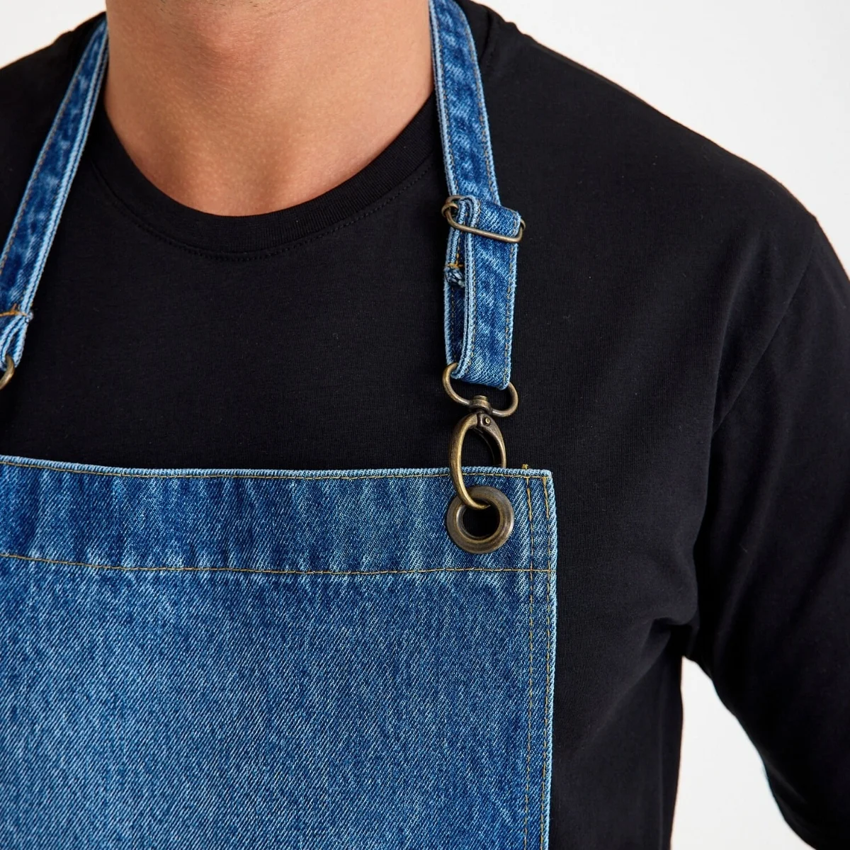 Kot denim önlüğün ayarlanabilir boyun askısı ve metal toka kanca bağlantısı yakın çekim